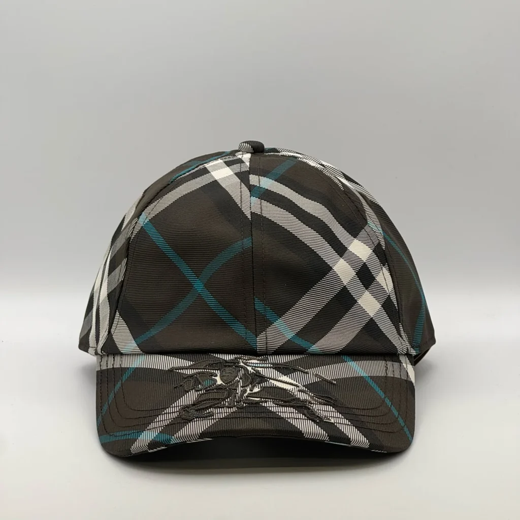 Dark brown check Burberry cap, front view showing the equestrian knight design on the brim.