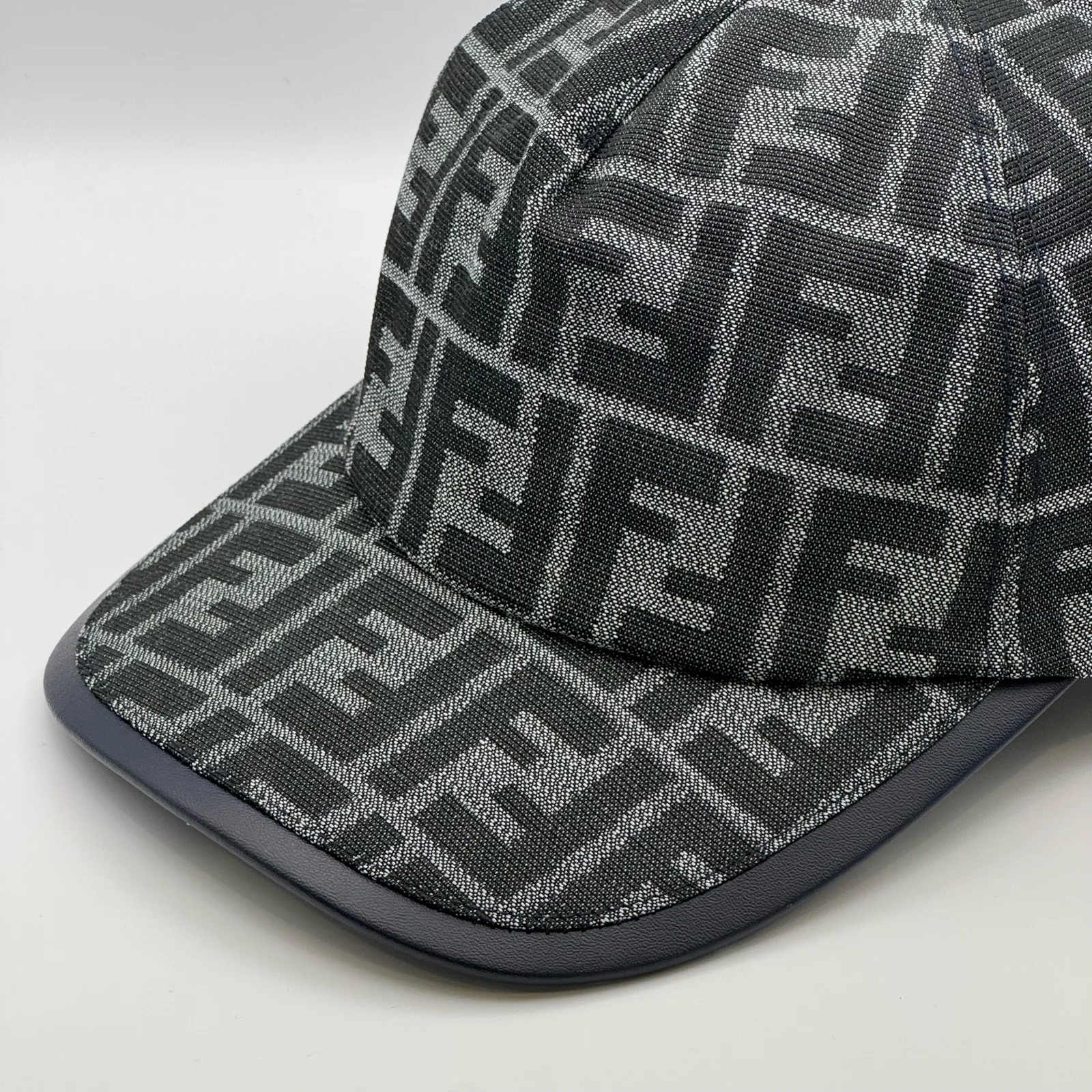 Charcoal grey Fendi FF cap, elevated three-quarter view of the crown.