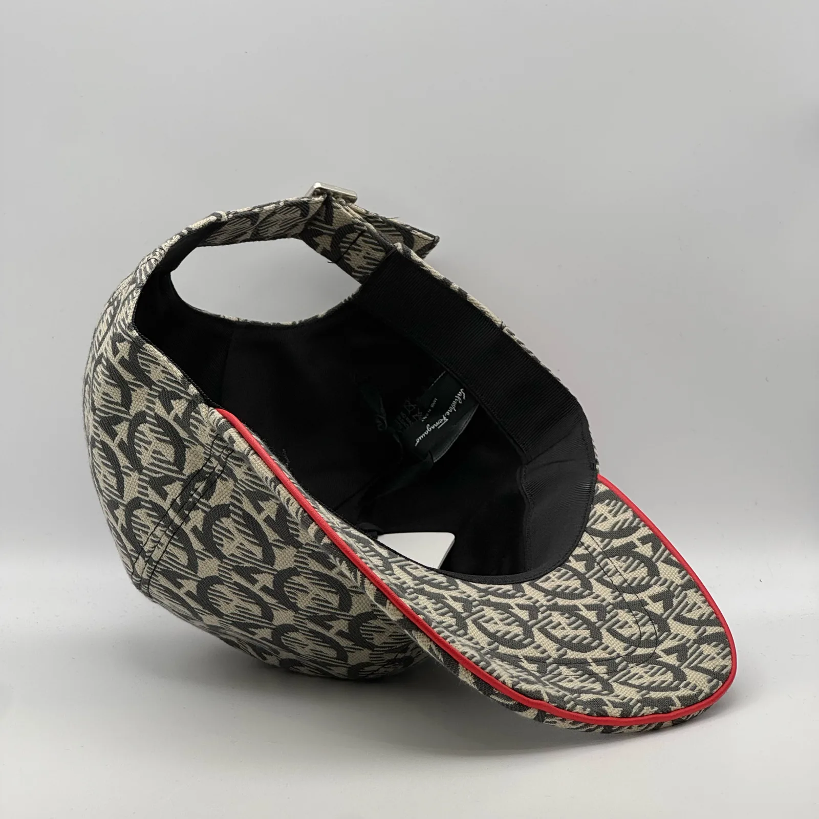 Ferragamo Gancini cap, underside view showing the black interior lining and red trim edge.