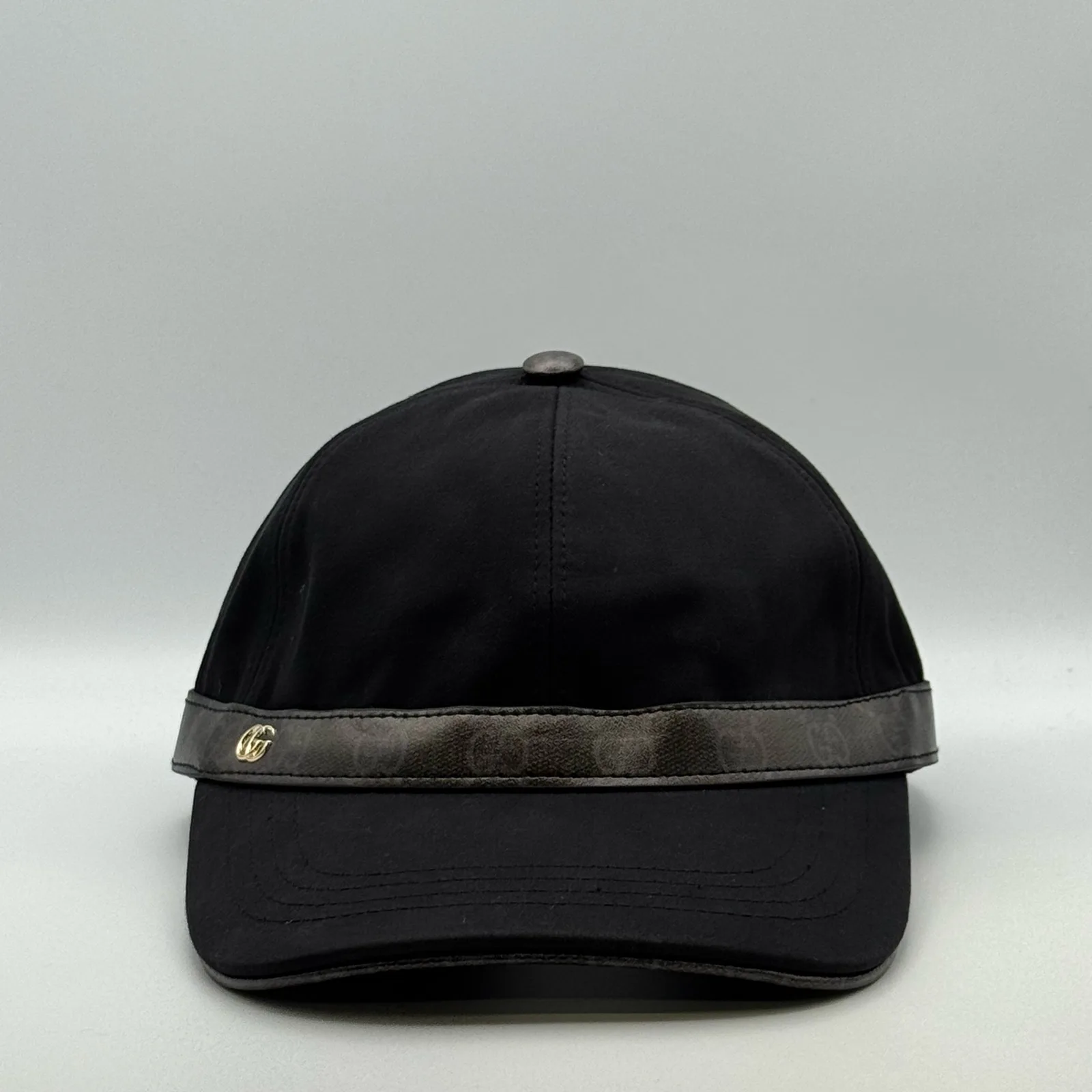 Black cap with GG canvas brim trim and gold-tone logo, front view