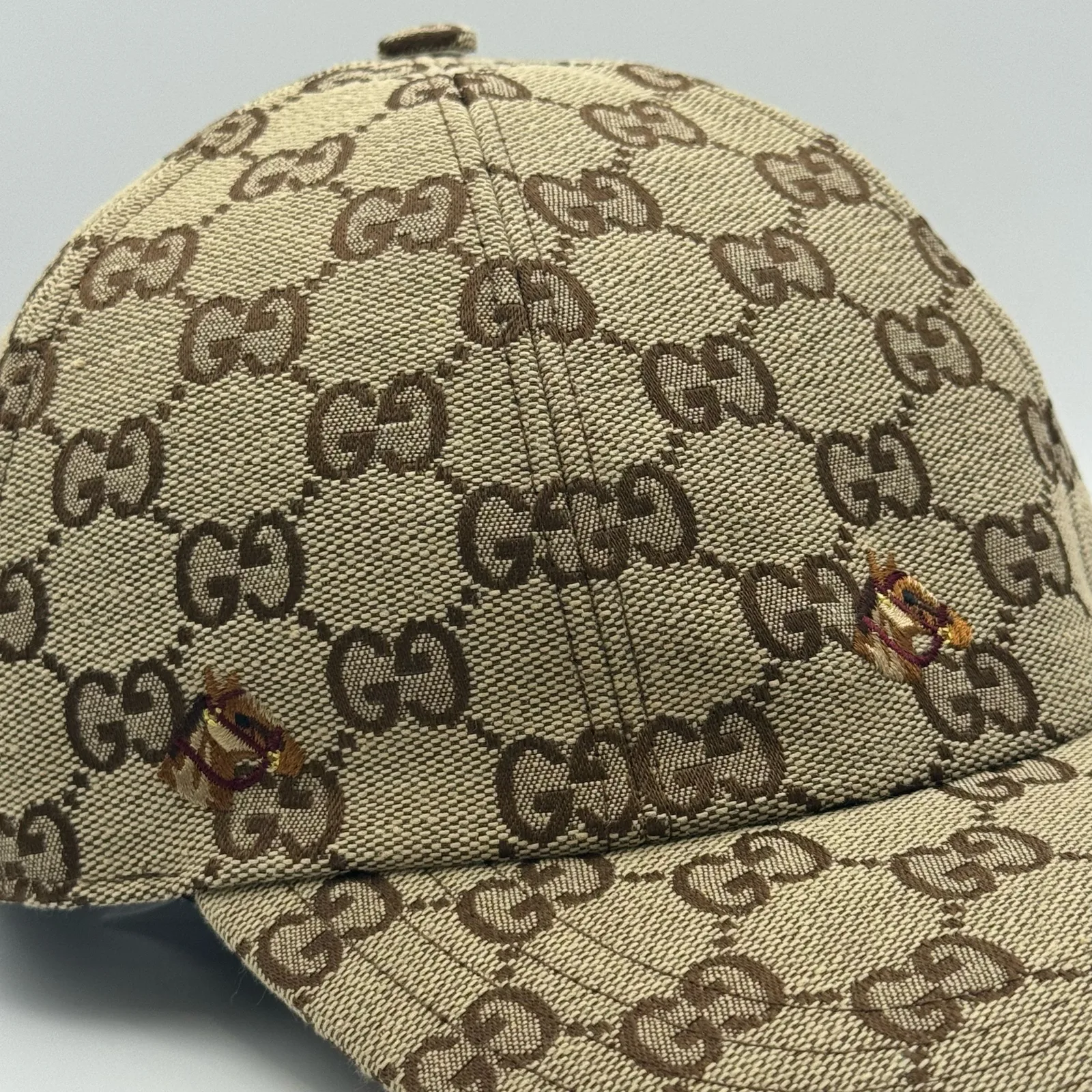 Beige GG canvas cap, close-up of the embroidered bee patch on the crown