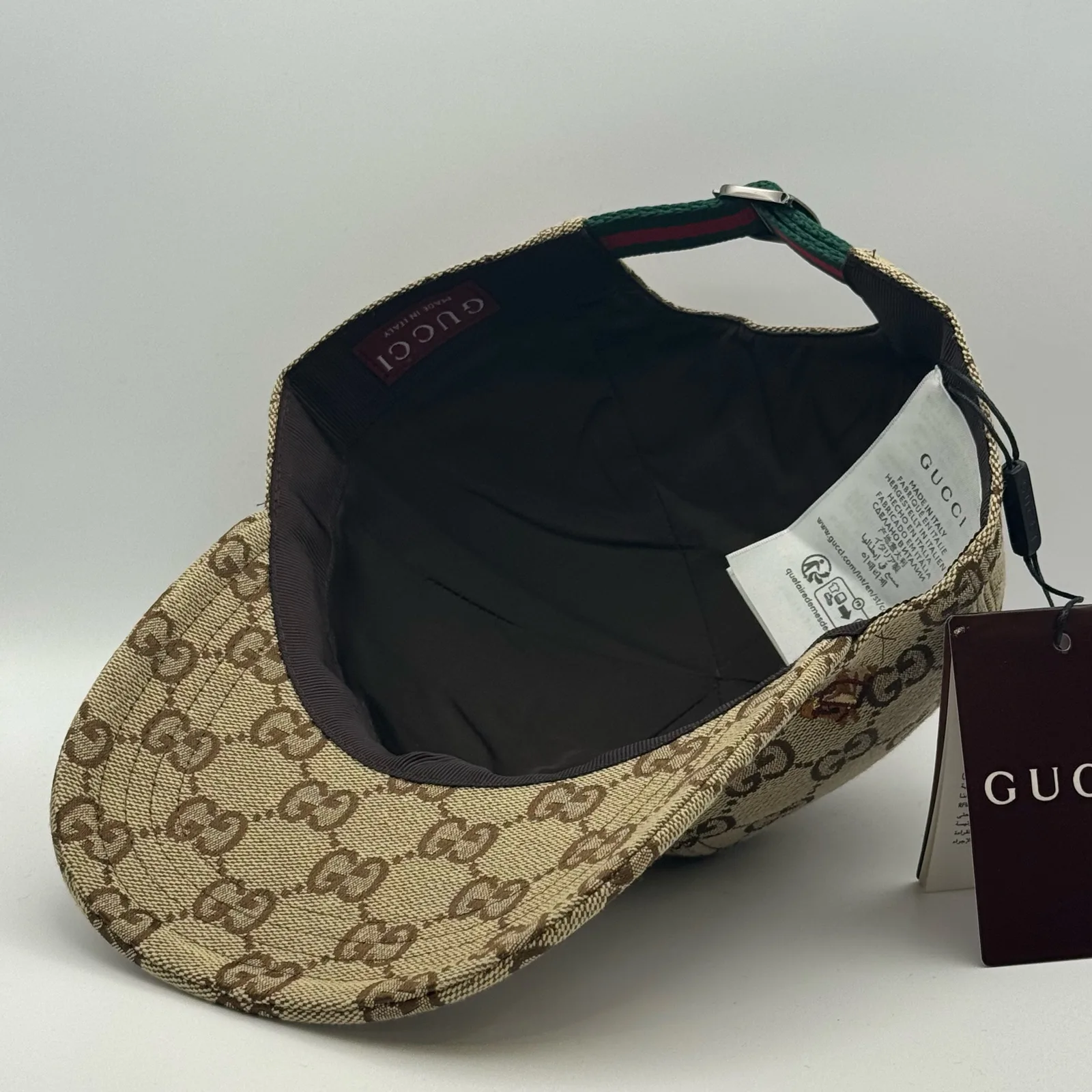 Beige GG canvas cap, interior view showing the black lining and hanging tag