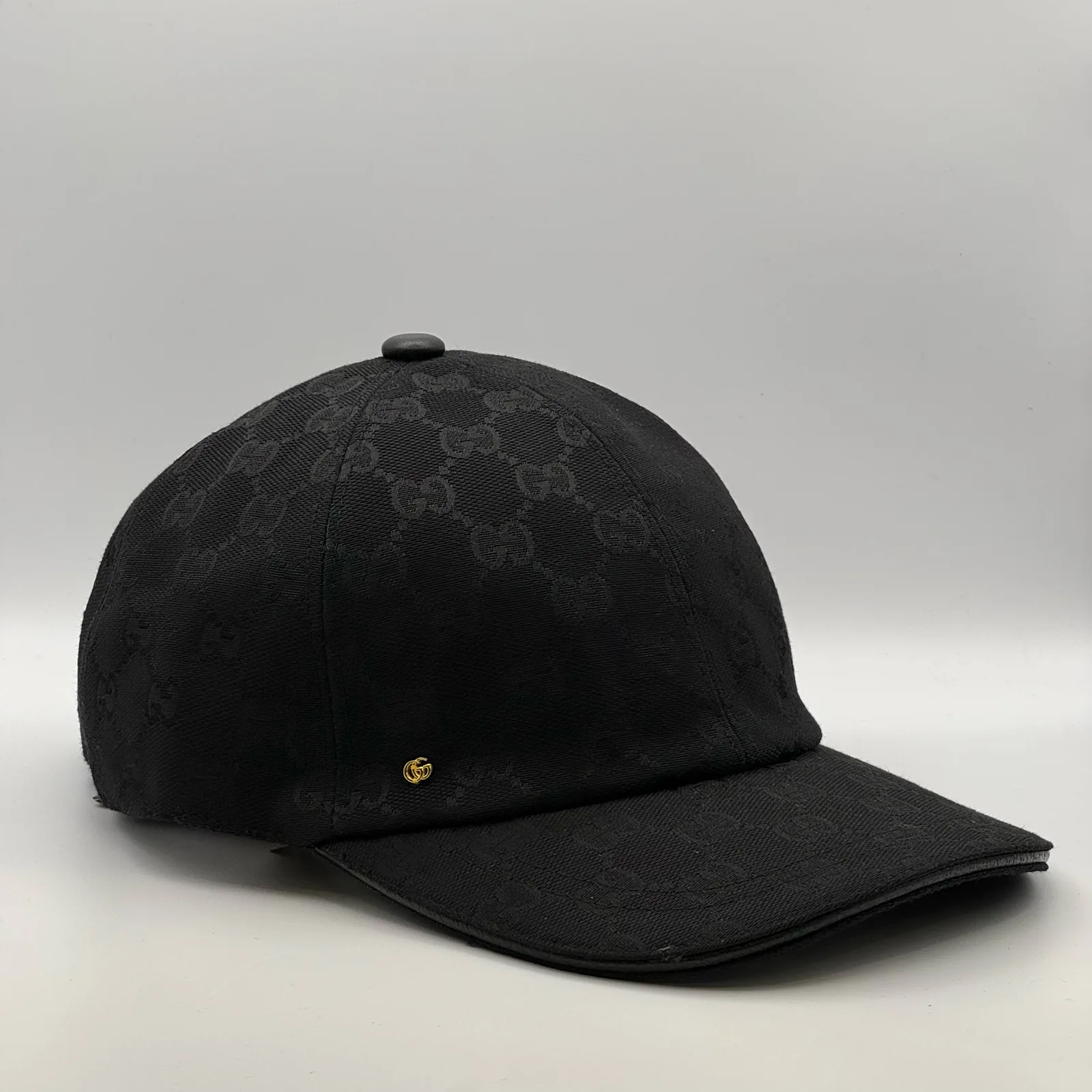 Black GG canvas cap, side view showing the black leather brim and strap