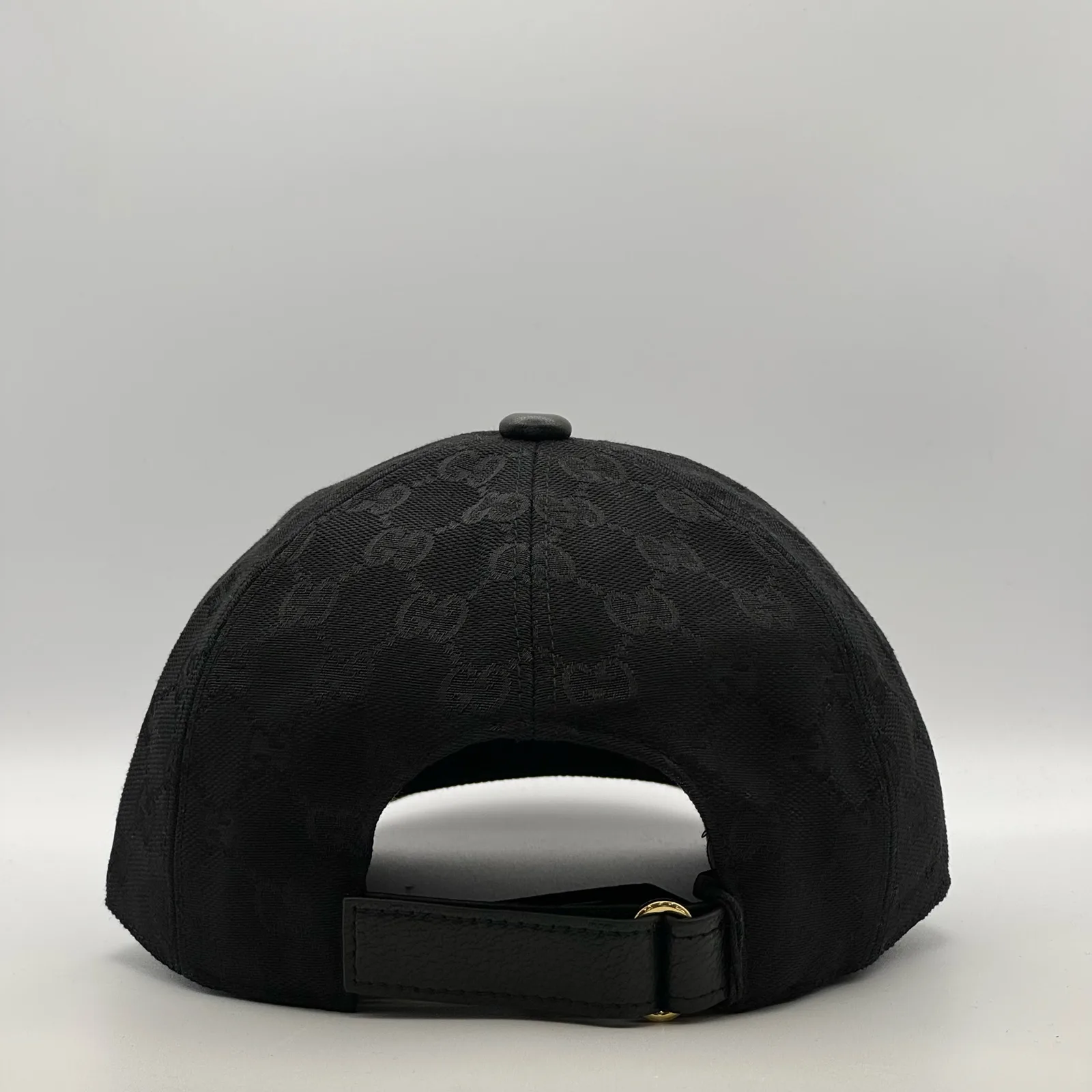 Black GG canvas cap, back view with black leather strap and gold-tone buckle