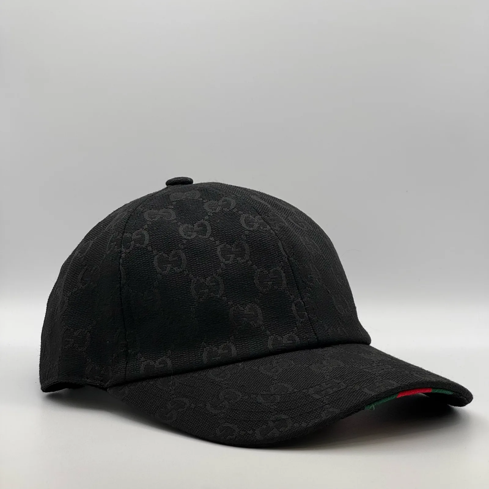 Black GG canvas cap, straight-on front view showing the red brim trim