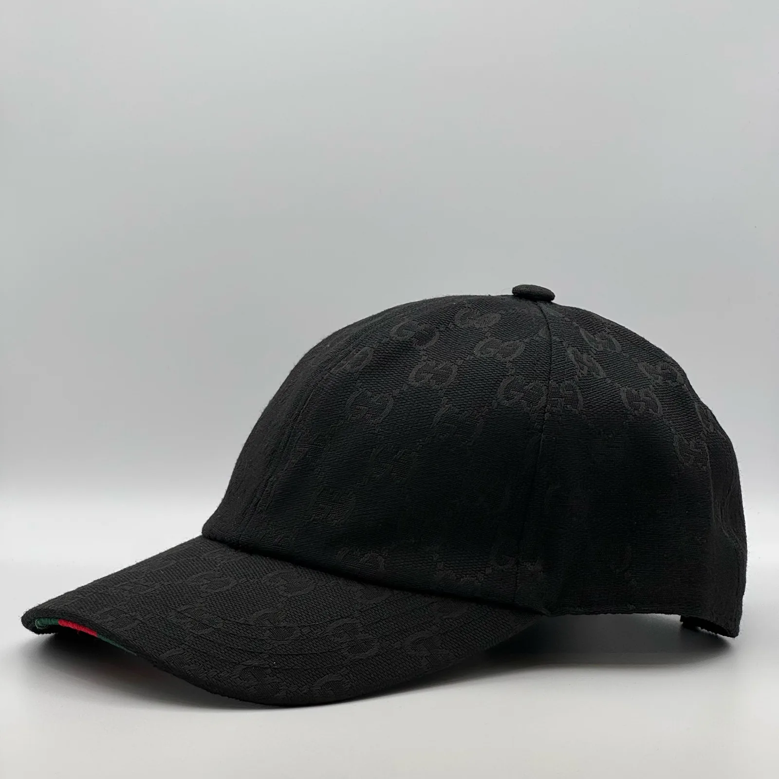 Black GG canvas cap, side view showing the black leather buckle strap