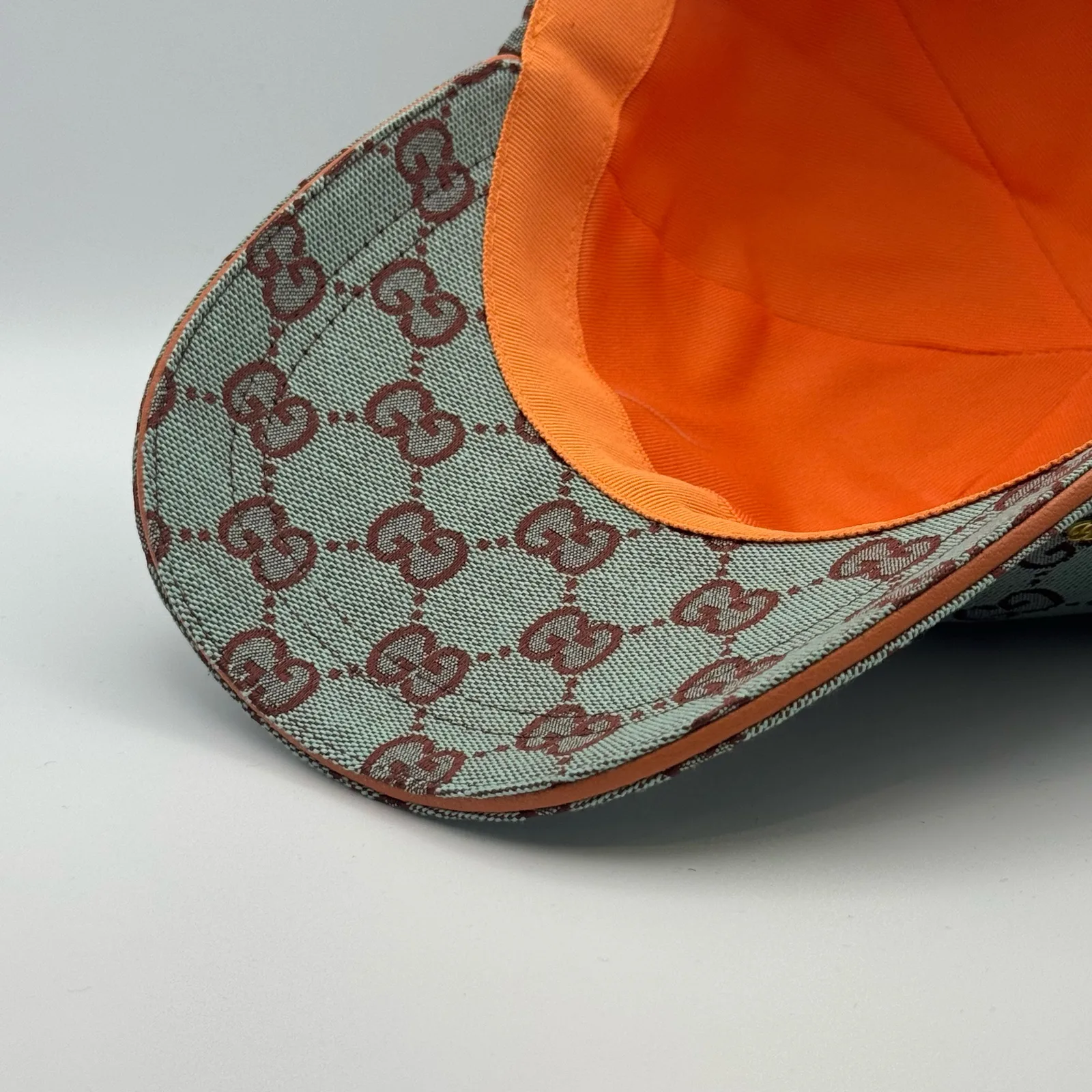 Mint green GG canvas cap, close-up of the brim underside in bright orange