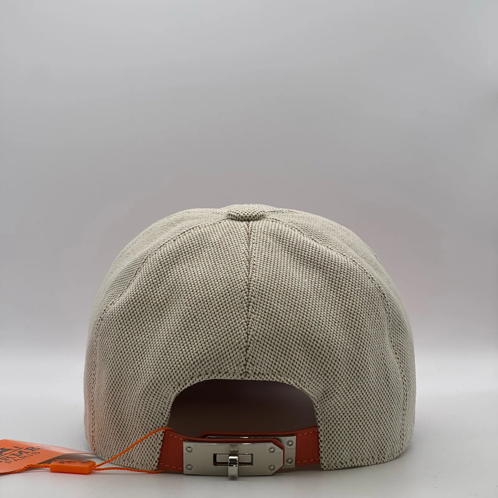 Hermès canvas cap, back view showing the leather strap and metal buckle closure.