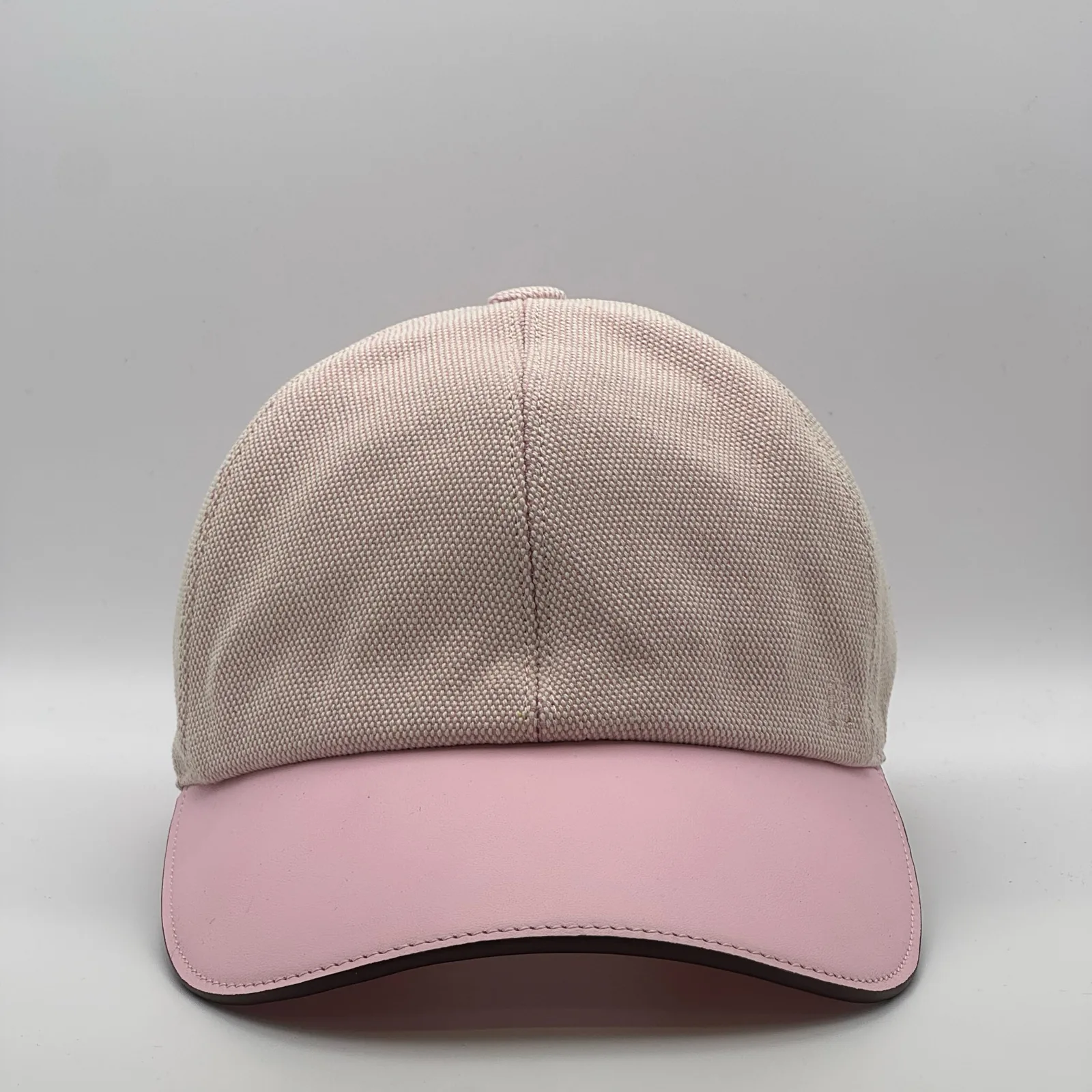 Hermès canvas cap, front view in oatmeal weave with a pink leather brim.