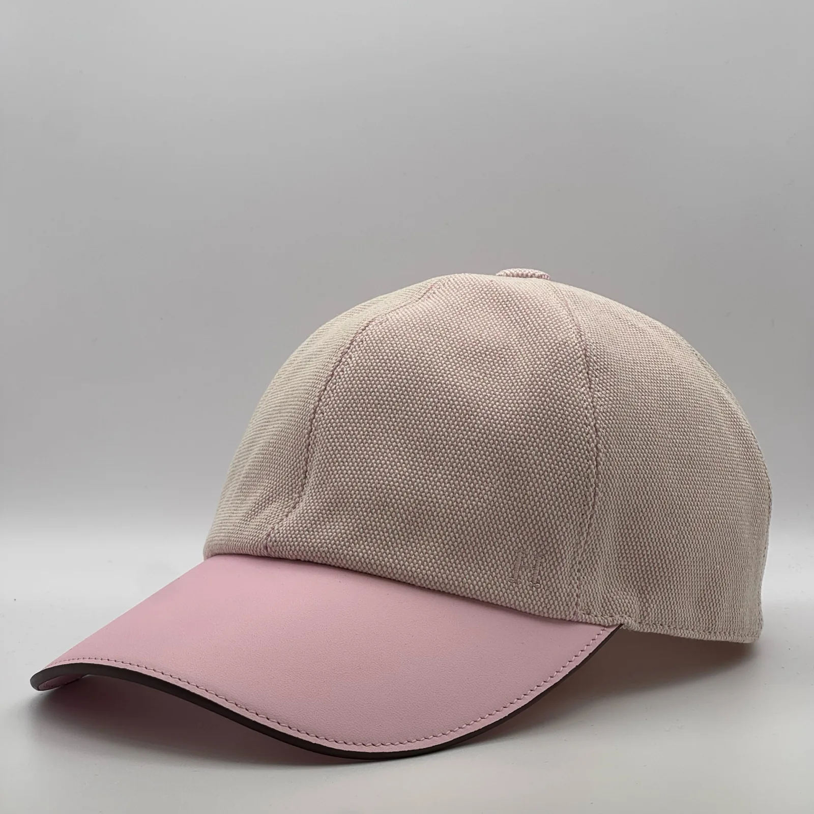Hermès canvas cap, side profile in woven canvas with a pink leather brim.