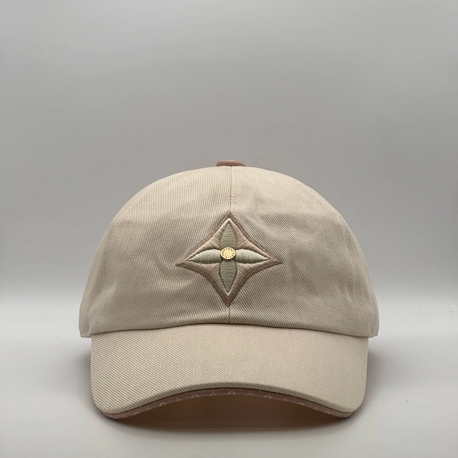Beige Louis Vuitton Monogram Flower cap, front view showing the tonal flower emblem.