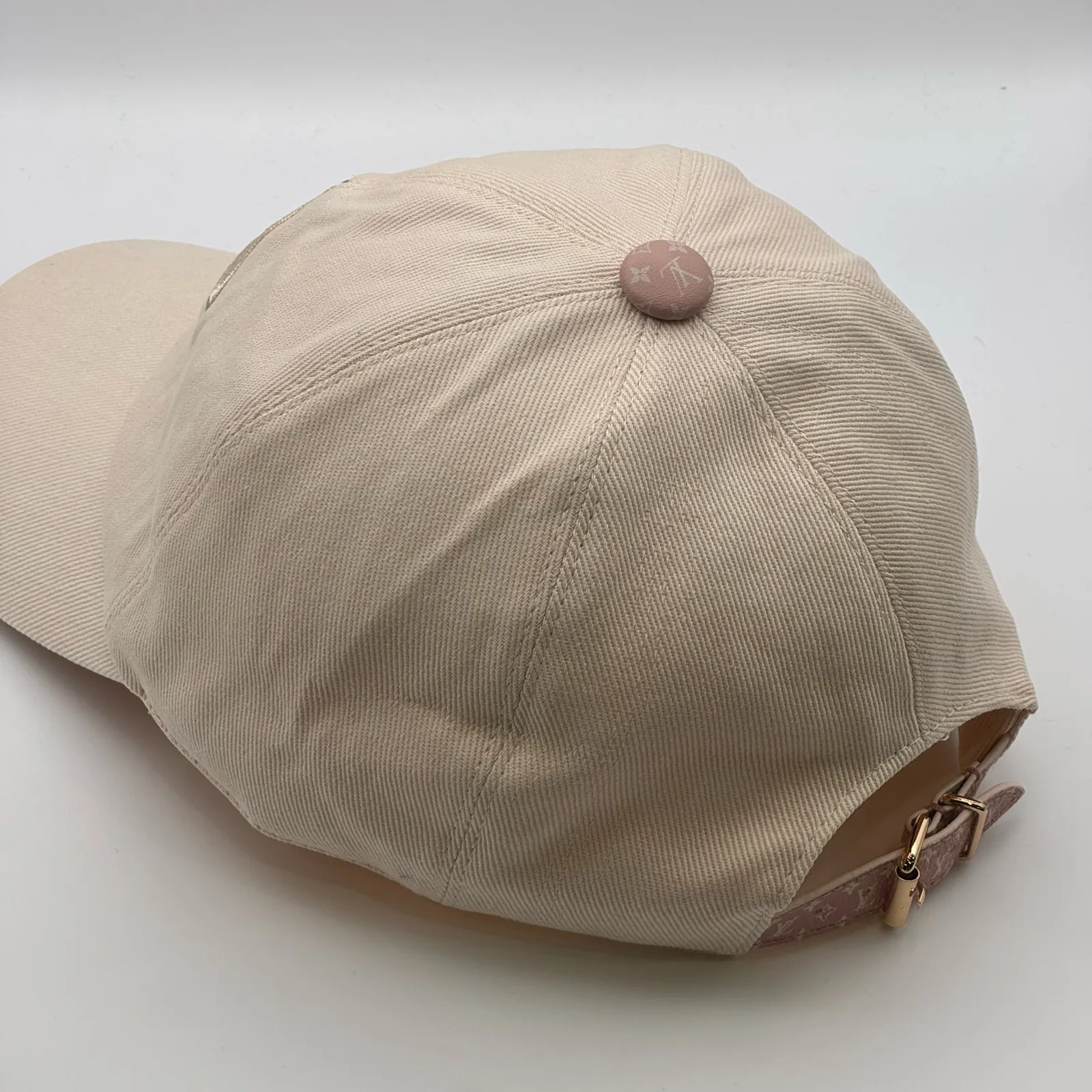 Beige flower cap, three-quarter angle showing crown and brim.